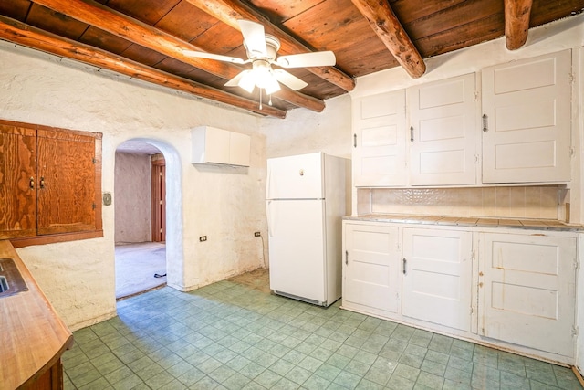 kitchen with ceiling fan, wood ceiling, white cabinets, white fridge, and beam ceiling