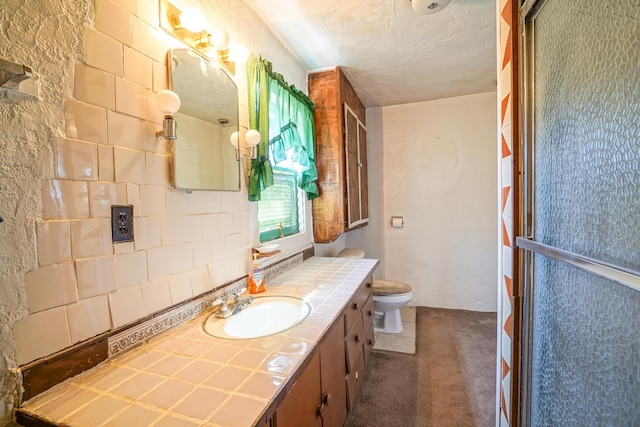 bathroom with vanity, a textured ceiling, backsplash, walk in shower, and toilet