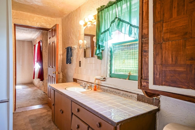 bathroom featuring decorative backsplash, plenty of natural light, and vanity