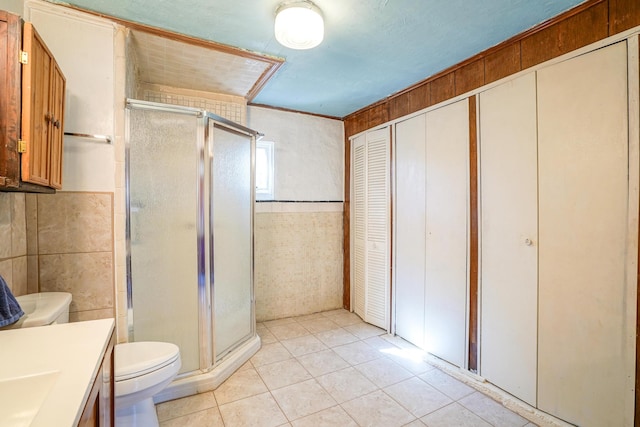 bathroom with an enclosed shower, vanity, tile patterned flooring, and toilet