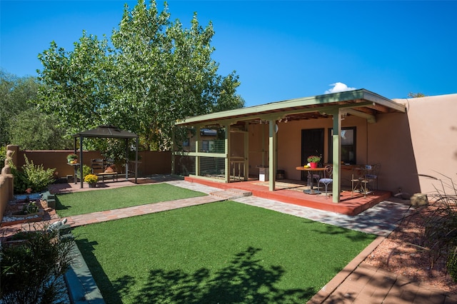 view of yard with ceiling fan, a gazebo, and a patio area