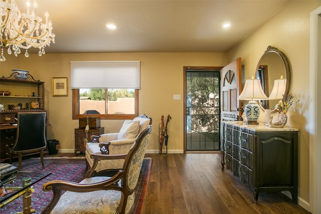 living area featuring an inviting chandelier and dark hardwood / wood-style flooring