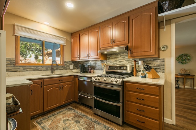 kitchen with tasteful backsplash, appliances with stainless steel finishes, sink, and dark hardwood / wood-style flooring