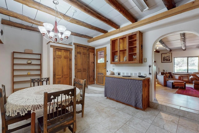 dining space featuring beamed ceiling, wood ceiling, a chandelier, and light hardwood / wood-style flooring