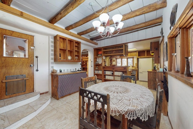 dining room with beamed ceiling and a chandelier