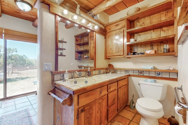 bathroom with vanity, beam ceiling, toilet, and tile patterned floors