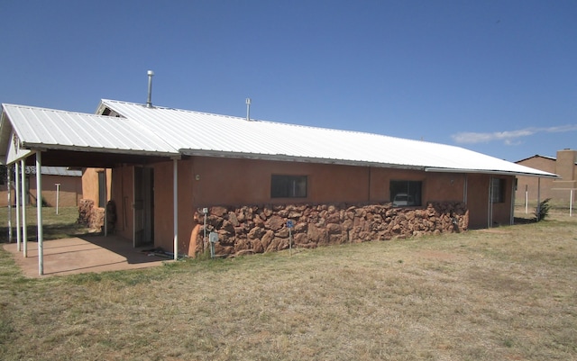 rear view of house with a lawn and a patio area