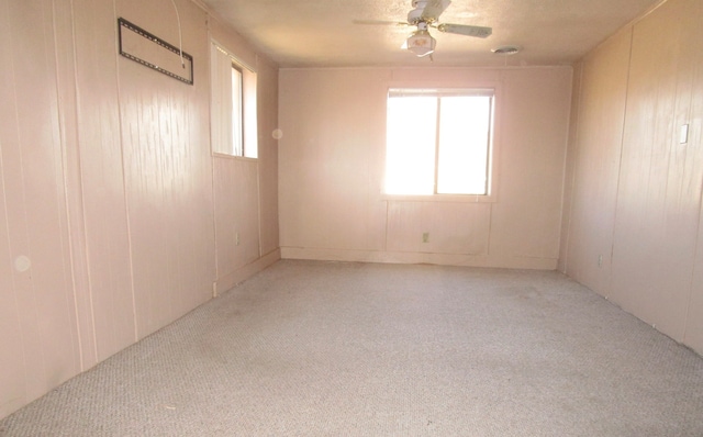 carpeted empty room featuring ceiling fan and plenty of natural light