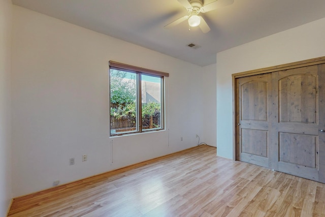 unfurnished bedroom featuring ceiling fan, light hardwood / wood-style flooring, and a closet