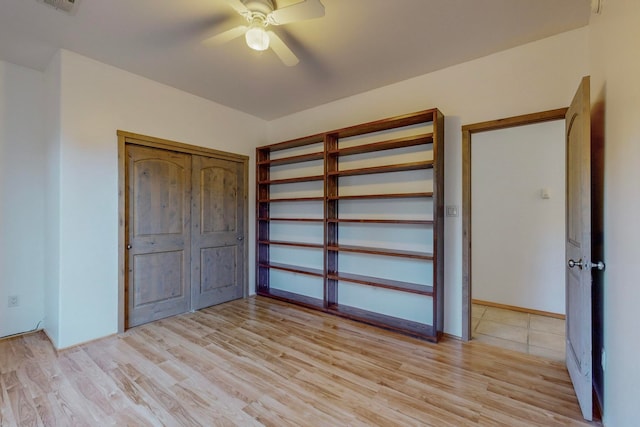 unfurnished bedroom with ceiling fan and light wood-type flooring