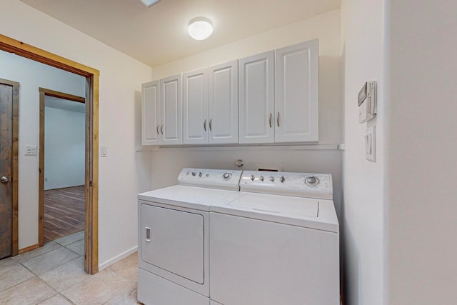 washroom featuring light wood-type flooring, independent washer and dryer, and cabinets