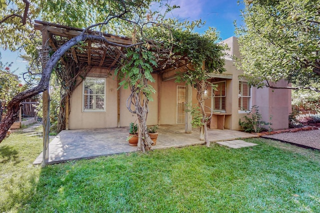 back of property featuring a lawn and a patio