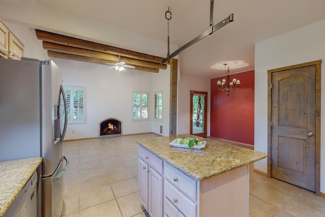 kitchen with decorative light fixtures, beam ceiling, stainless steel fridge, and a center island