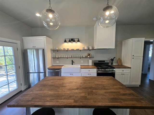 kitchen featuring dark hardwood / wood-style floors, appliances with stainless steel finishes, sink, and white cabinetry