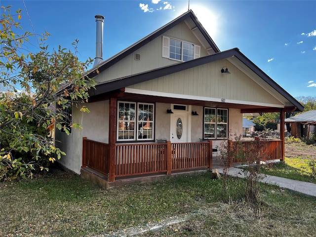 bungalow-style house with a front lawn and covered porch