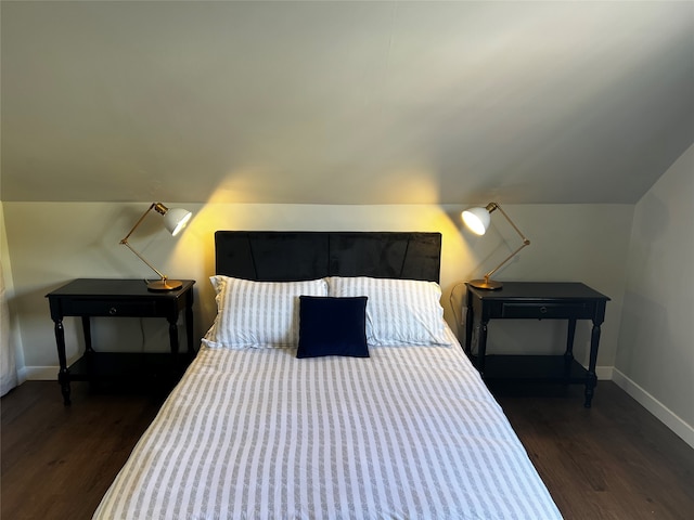 bedroom with vaulted ceiling and dark hardwood / wood-style flooring