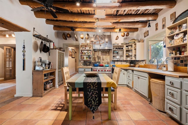 kitchen featuring pendant lighting, wooden ceiling, beam ceiling, sink, and white cabinets