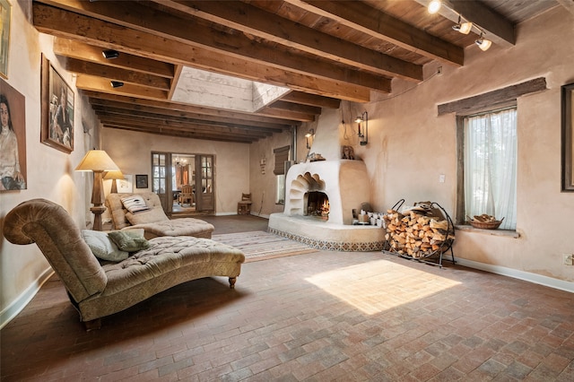 sitting room with a skylight, beamed ceiling, and wooden ceiling