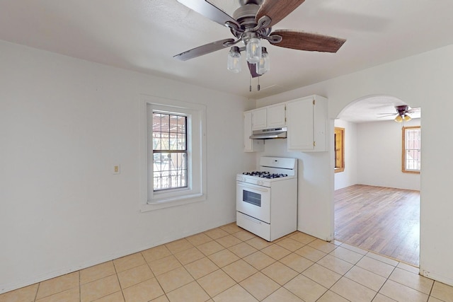 kitchen featuring white range with gas stovetop, plenty of natural light, white cabinetry, and light hardwood / wood-style flooring