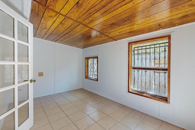 unfurnished room with light tile patterned floors and wooden ceiling