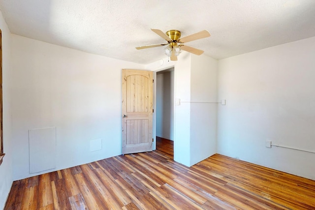 spare room with wood-type flooring, ceiling fan, and a textured ceiling