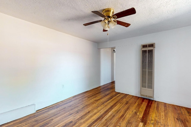 spare room with a textured ceiling, wine cooler, ceiling fan, and dark hardwood / wood-style flooring