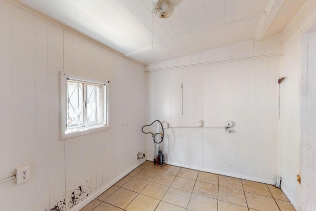 spare room with wood walls and light tile patterned floors