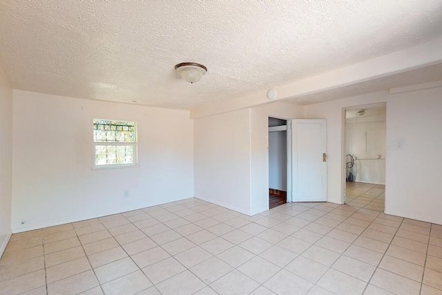 tiled empty room with a textured ceiling