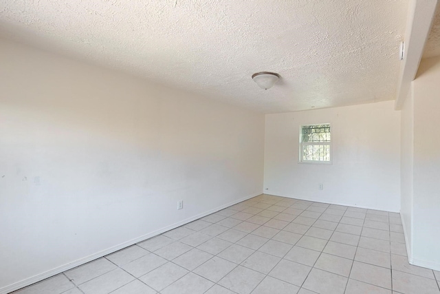 unfurnished room featuring light tile patterned floors and a textured ceiling