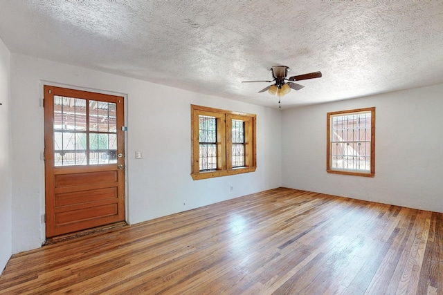 foyer entrance featuring a textured ceiling, ceiling fan, and light hardwood / wood-style flooring