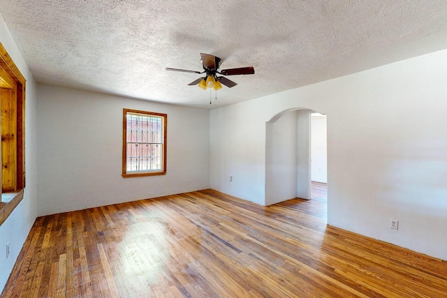 empty room with ceiling fan, a textured ceiling, and light hardwood / wood-style flooring