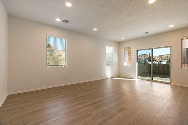 spare room featuring a textured ceiling and wood-type flooring