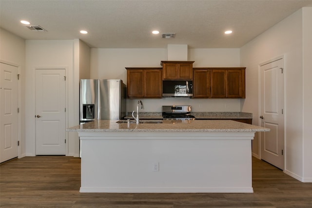 kitchen with an island with sink, dark hardwood / wood-style floors, sink, and stainless steel appliances