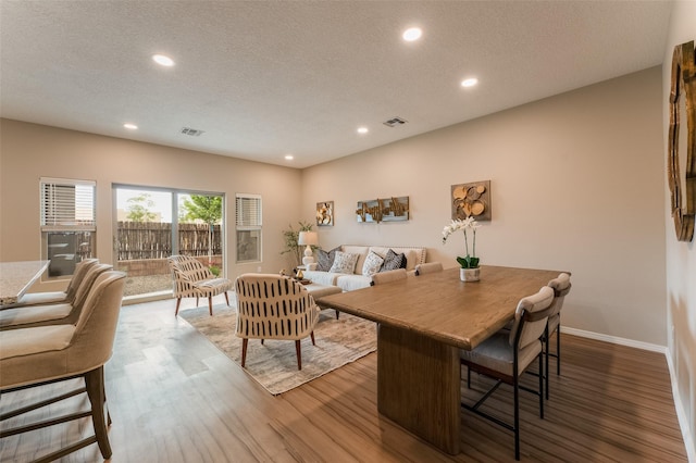 dining room featuring hardwood / wood-style floors and a textured ceiling