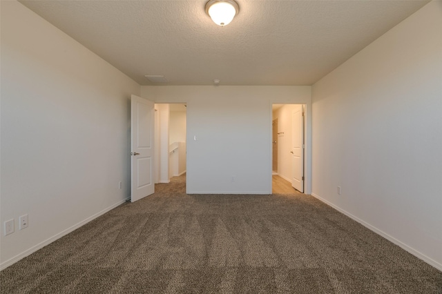 unfurnished bedroom with a textured ceiling and carpet flooring