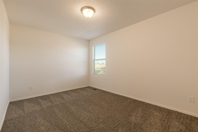 carpeted spare room with a textured ceiling