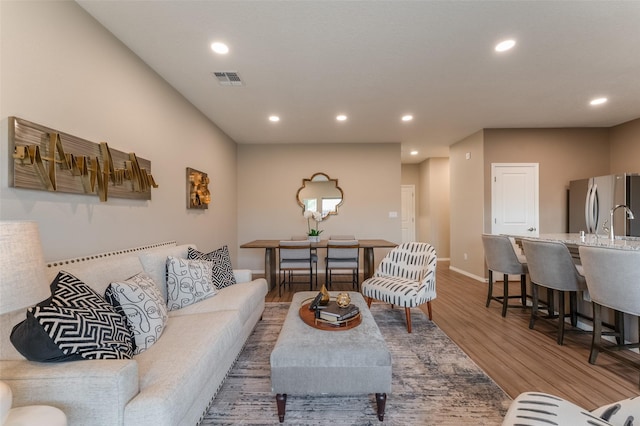 living room featuring sink and hardwood / wood-style floors