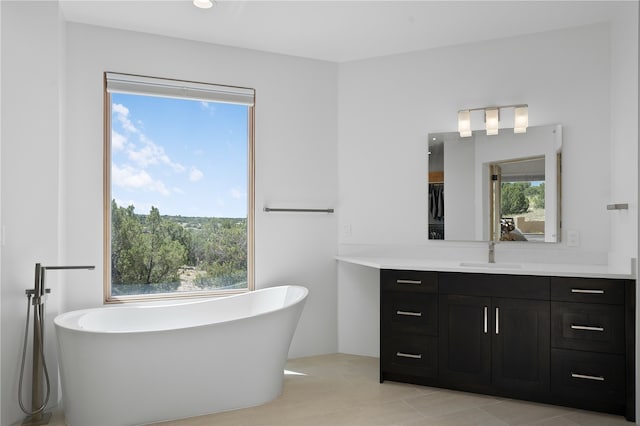 bathroom with vanity, tile patterned floors, a bathtub, and a healthy amount of sunlight