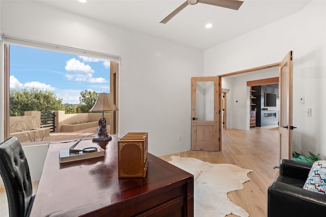 home office with light wood-type flooring and ceiling fan