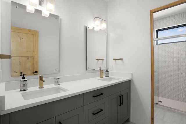 bathroom with a tile shower and vanity