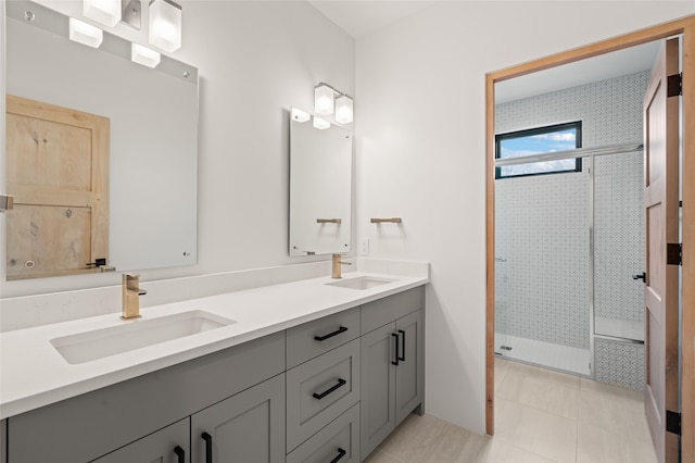 bathroom with tile patterned flooring, vanity, and tiled shower