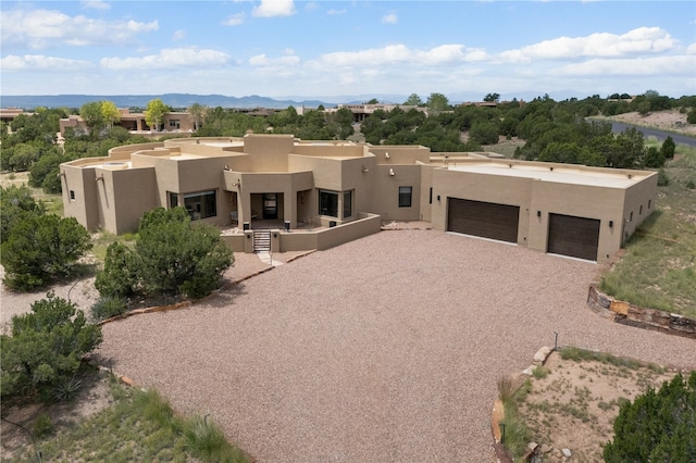 pueblo-style home featuring a mountain view and a garage