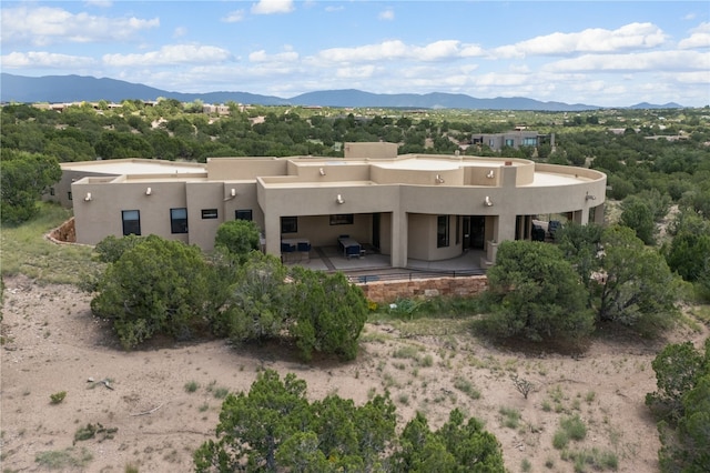 rear view of property with a mountain view and a patio area