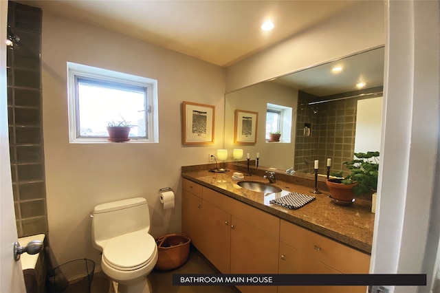 bathroom featuring vanity, toilet, and tiled shower