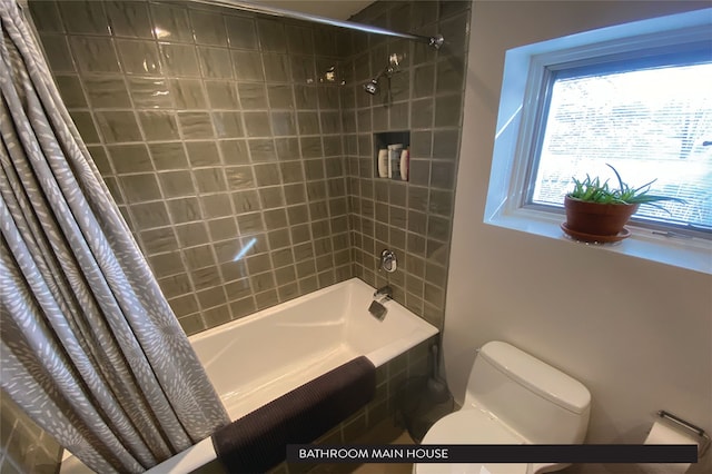 bathroom with shower / bath combination with curtain and toilet