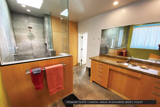 bathroom featuring vanity, concrete flooring, and tiled shower