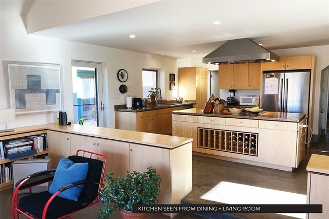 kitchen featuring stainless steel refrigerator, island exhaust hood, kitchen peninsula, and a kitchen island