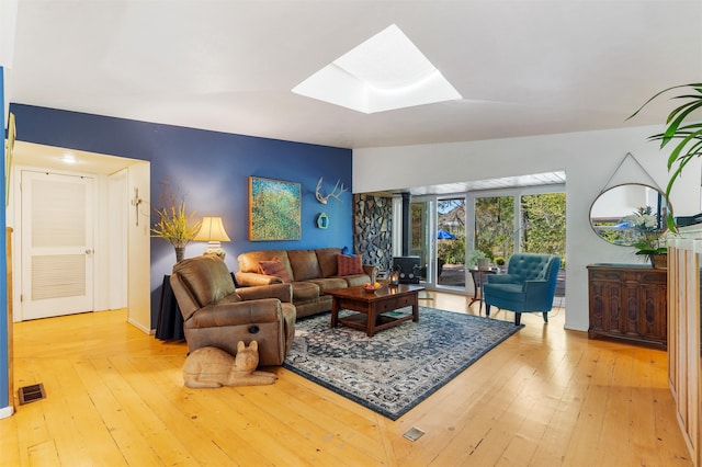 living room with a skylight and hardwood / wood-style floors