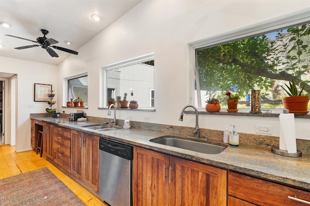 kitchen featuring sink, light wood-type flooring, lofted ceiling, and stainless steel dishwasher