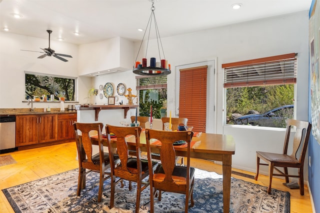 dining room featuring sink, ceiling fan with notable chandelier, and light hardwood / wood-style floors